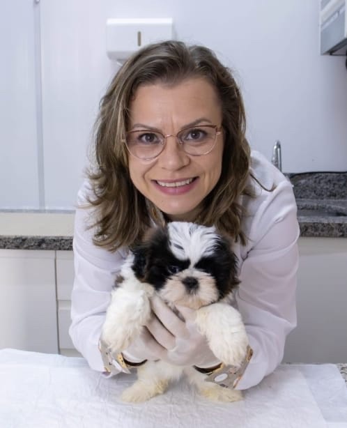 Tatiana Palma Durlo segurando um cachorrinho no consultório